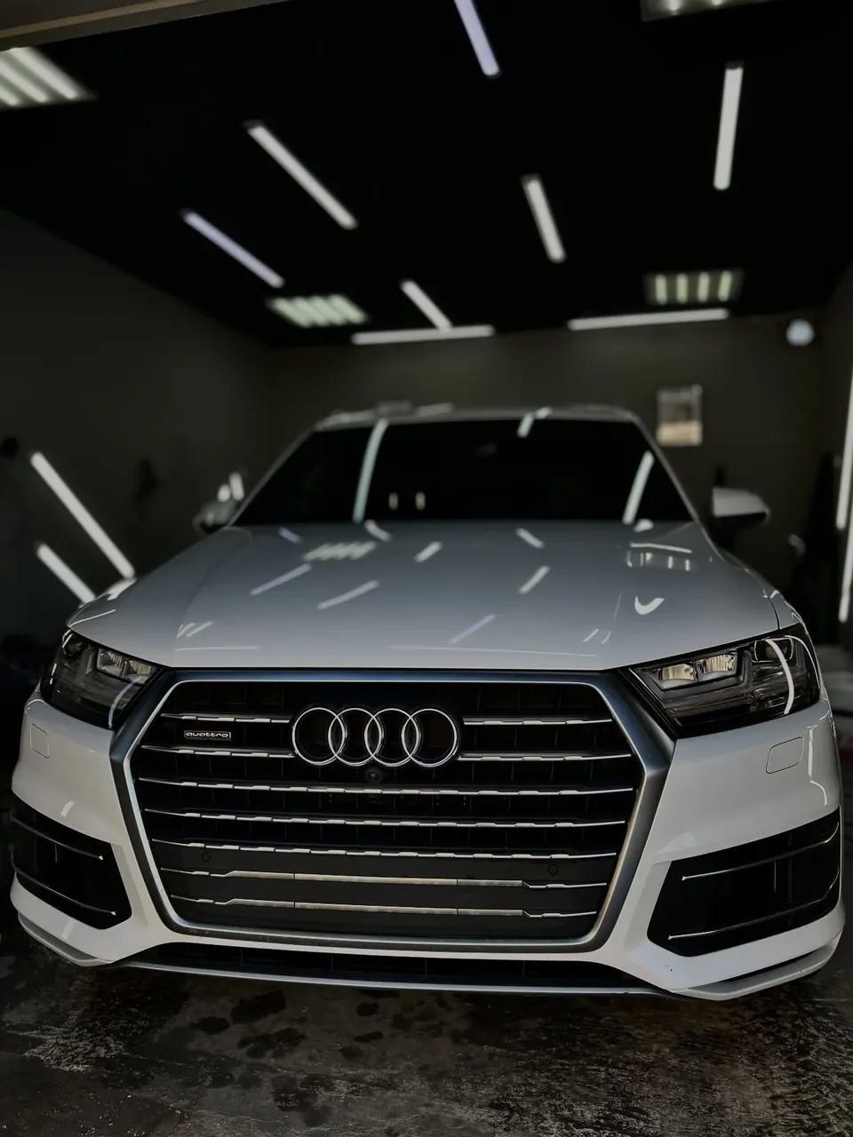 Белый Audi Q7 в боксе, рамка VAXO