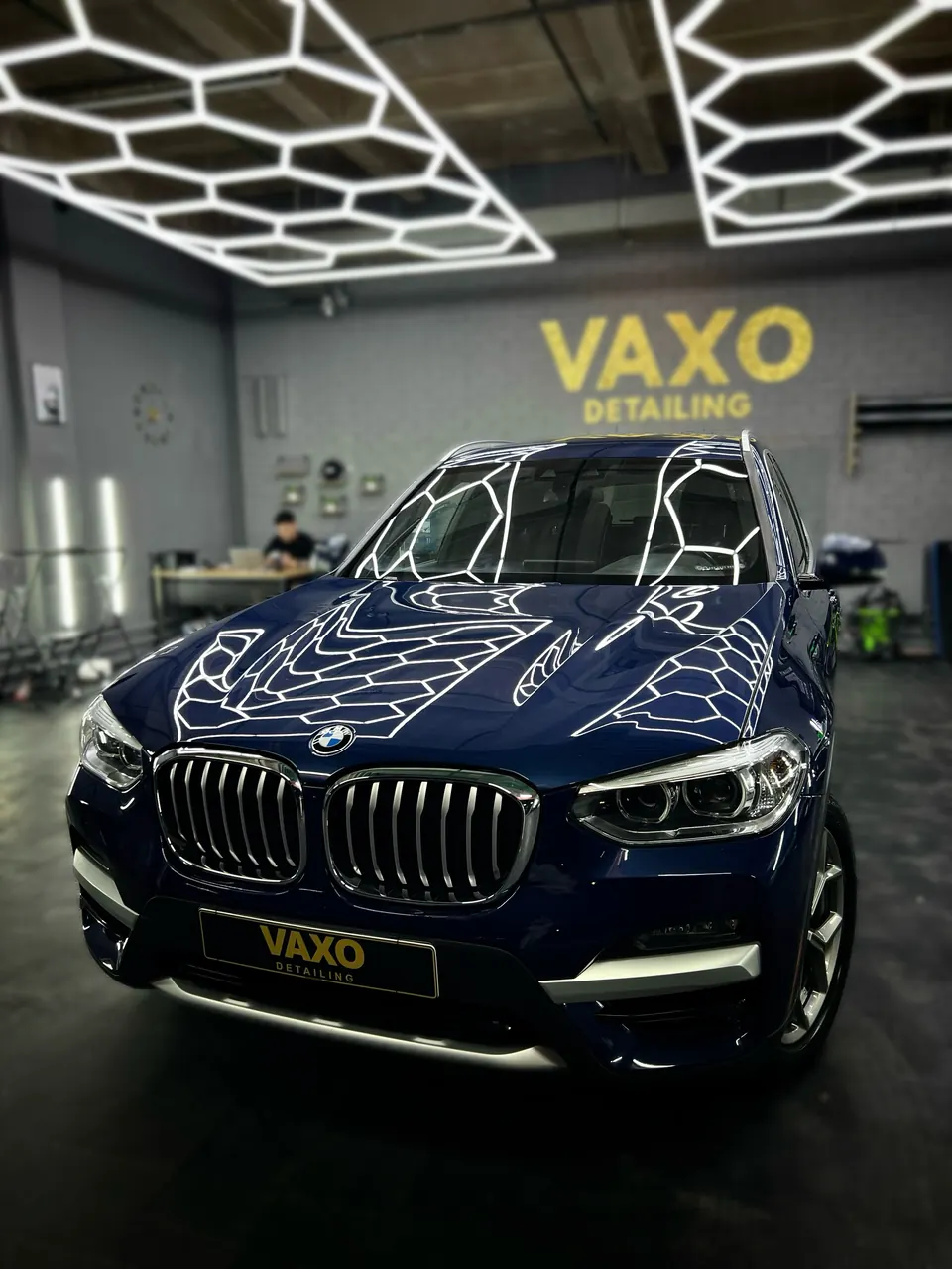 Синий BMW X3 под гекса-светом у стены VAXO