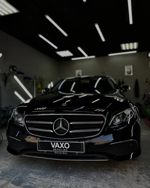 Чёрный Mercedes-Benz E анфас в боксе